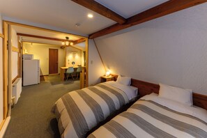 A hotel room with two beds, a kitchenette, a dining area, and a bathroom. - Madarao Vacances Village (Myoko)