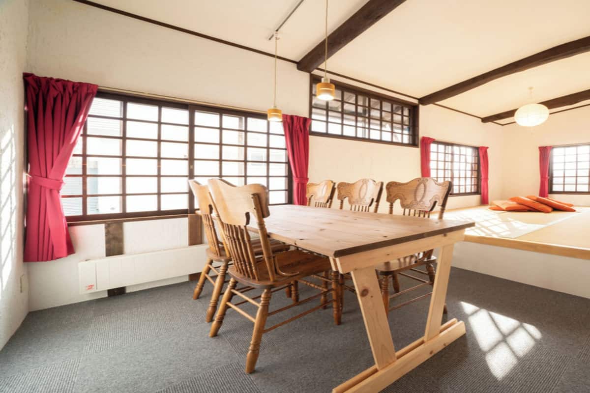 A traditional Japanese-style room with tatami flooring, a low wooden table, and a futon bed.