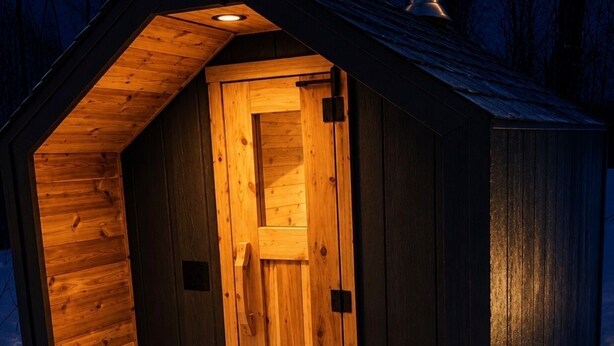 Una cabana de fusta amb una porta i un petit porxo.