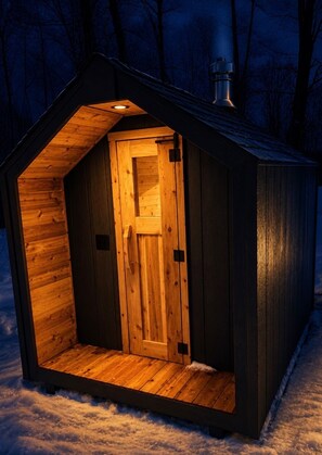 Uma cabana de madeira com uma porta e um pequeno alpendre.