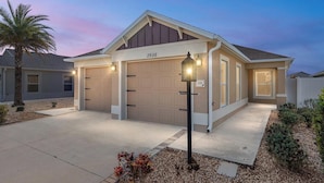 A two-story house with a garage numbered 2936, a well-lit entrance, and a small garden area.