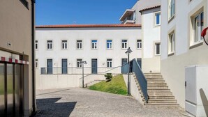 A building with a courtyard, a staircase, and a small hill. - Stylish Studio w/ Balcony & Garage by HostWise (Porto)