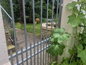 Stroll through the serene garden, surrounded by lush greenery and a tranquil stone planter.