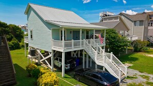 A two-story house with a balcony, a garage, and a driveway. - 3-bedroom house in fantastic family-friendly Surf City, 2 min walk to the beach. (Surf City)