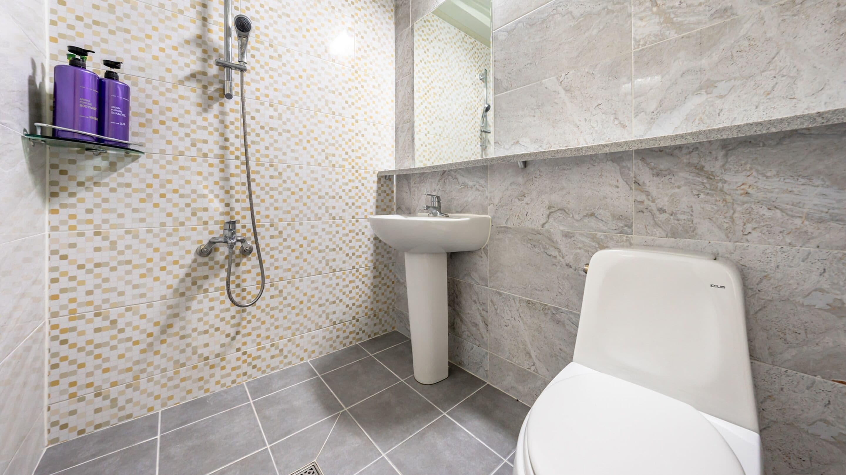 A bathroom with a shower, sink, and toilet.