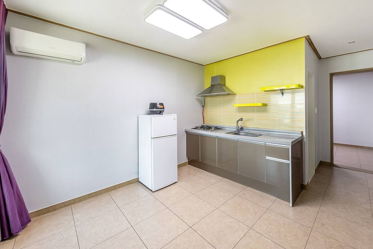 A compact kitchen with a refrigerator, stove, and sink.