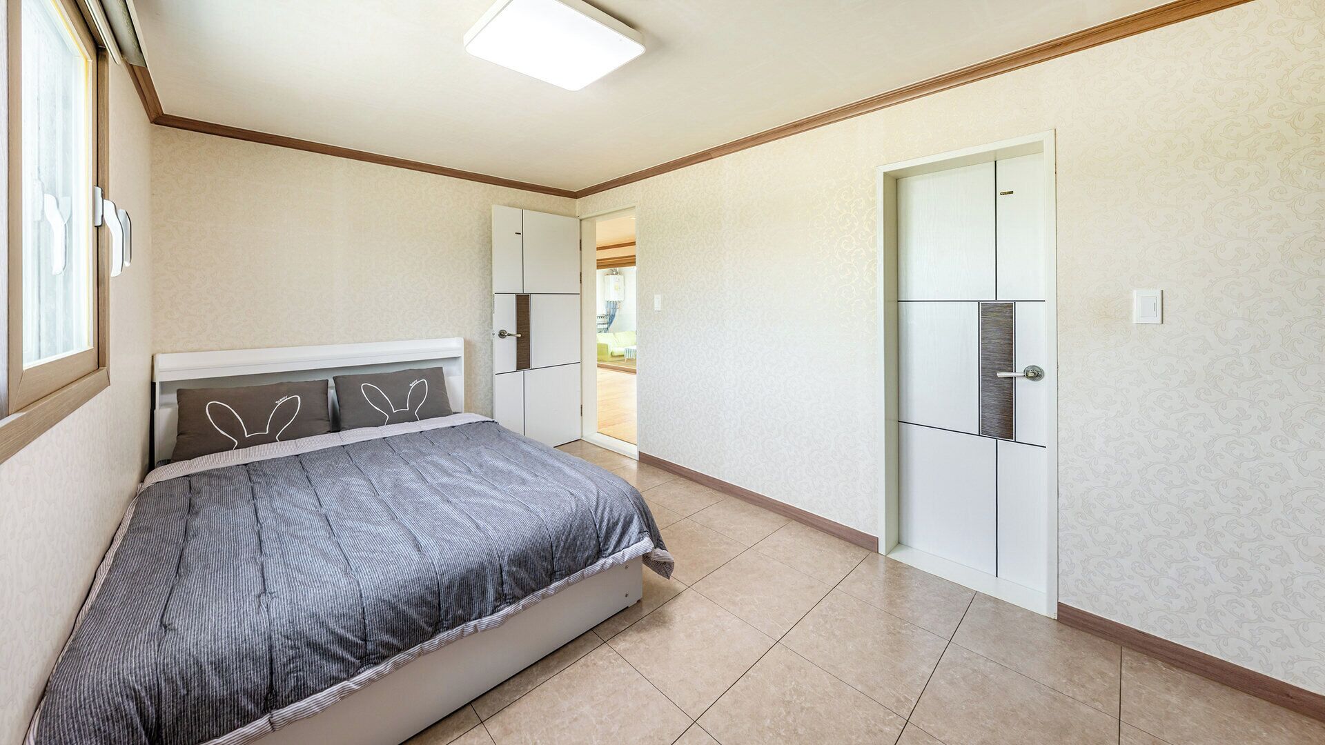 A bedroom with a bed, wardrobe, and a door leading to a balcony.