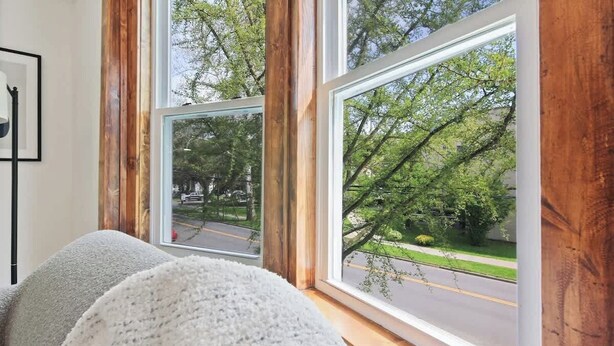 A room with a large window offering a view of a street and trees. - NY Suite | Downtown walk to Commons | Free Parking (Ithaca)