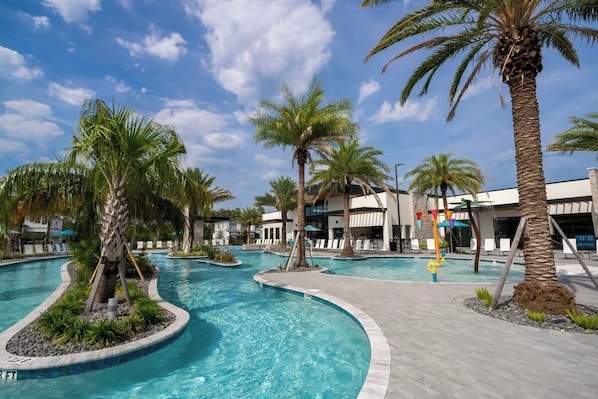 A swimming pool with palm trees, a lounge area, and a building with a modern design.