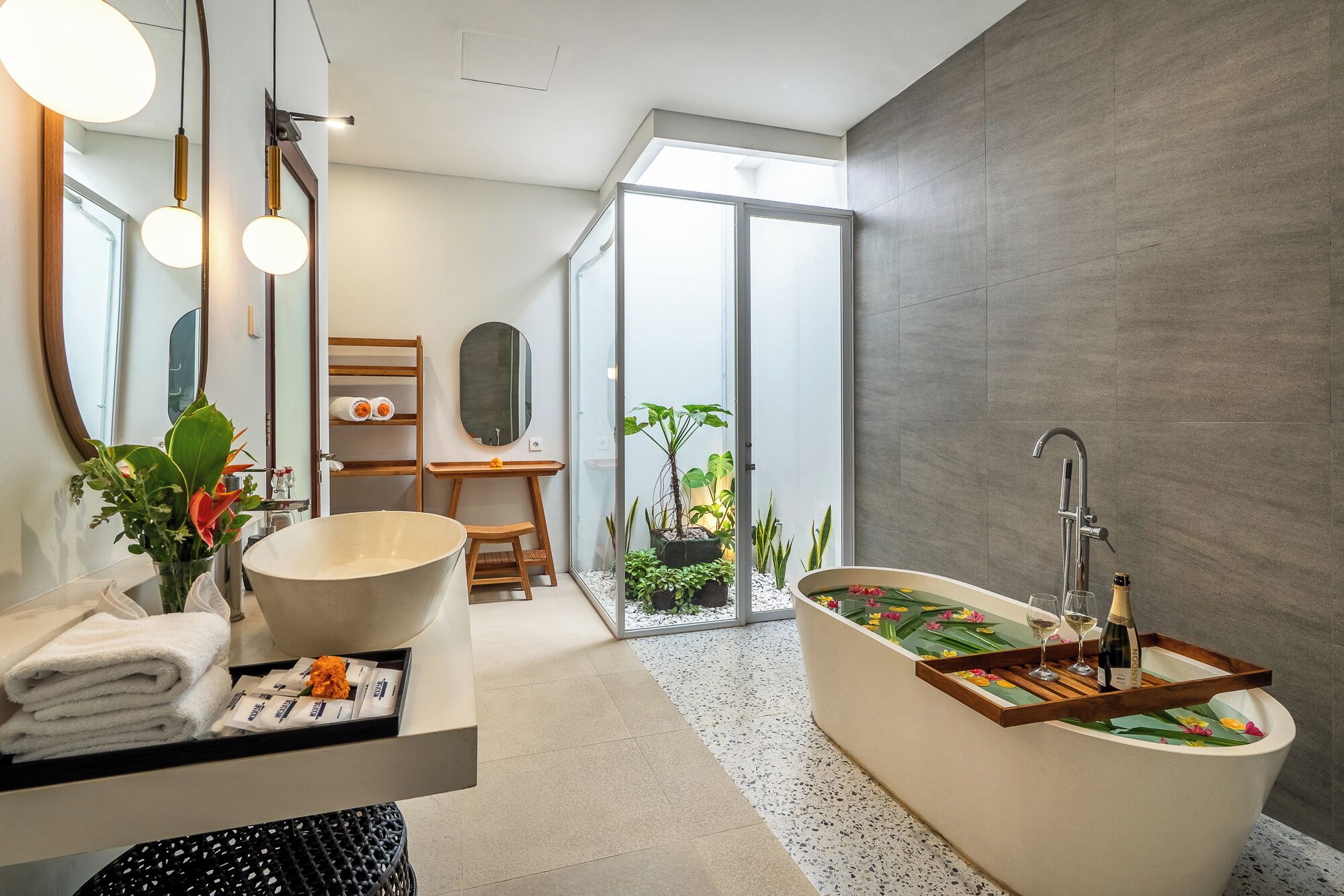 A modern bathroom with a freestanding bathtub, a large mirror, and a vanity with a sink.