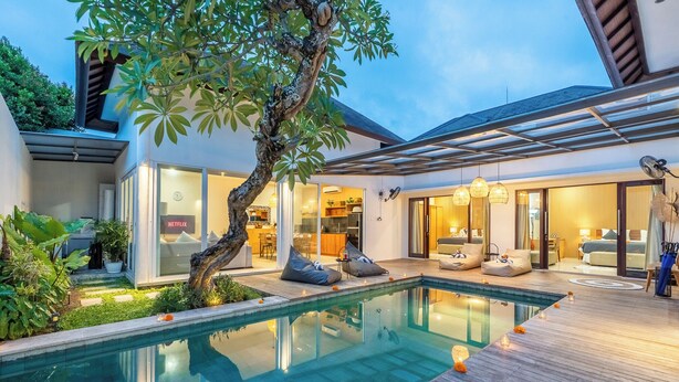 A modern house with a swimming pool, a covered patio, and a visible kitchen area. - Silk Umalas by Nagisa Bali (Kerobokan)