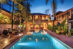 A poolside area with lounge chairs, a bar, and a pool. - Moon Gang (Ubud)
