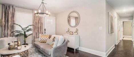 A living room with a grey sofa, a round coffee table, and a white side table.