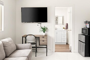 Bright and modern living space with a mounted TV and work desk.