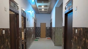 Un pasillo con puertas a ambos lados, una puerta central y un piso con diseño.
