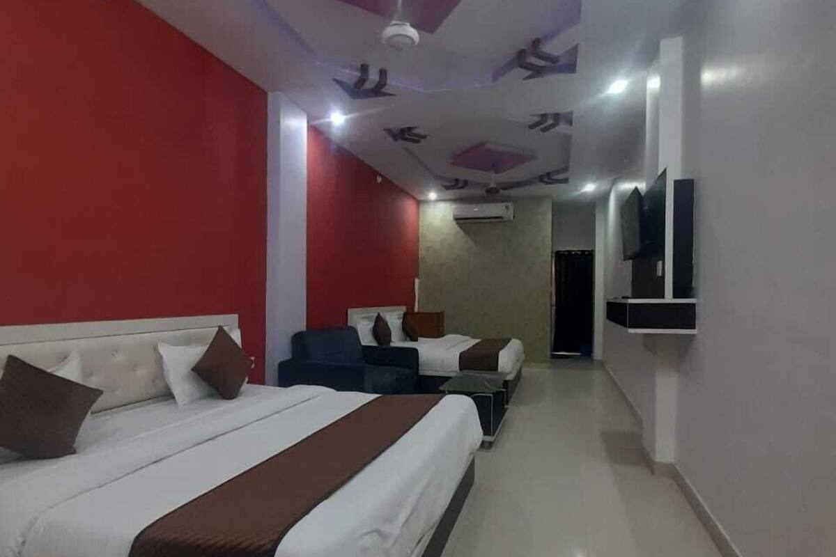 A hotel room with a bed, a desk, a chair, a TV, and a ceiling fan.