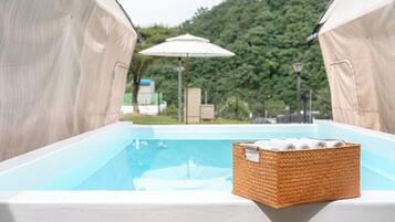 Una piscina con una cesta de mimbre que contiene toallas.