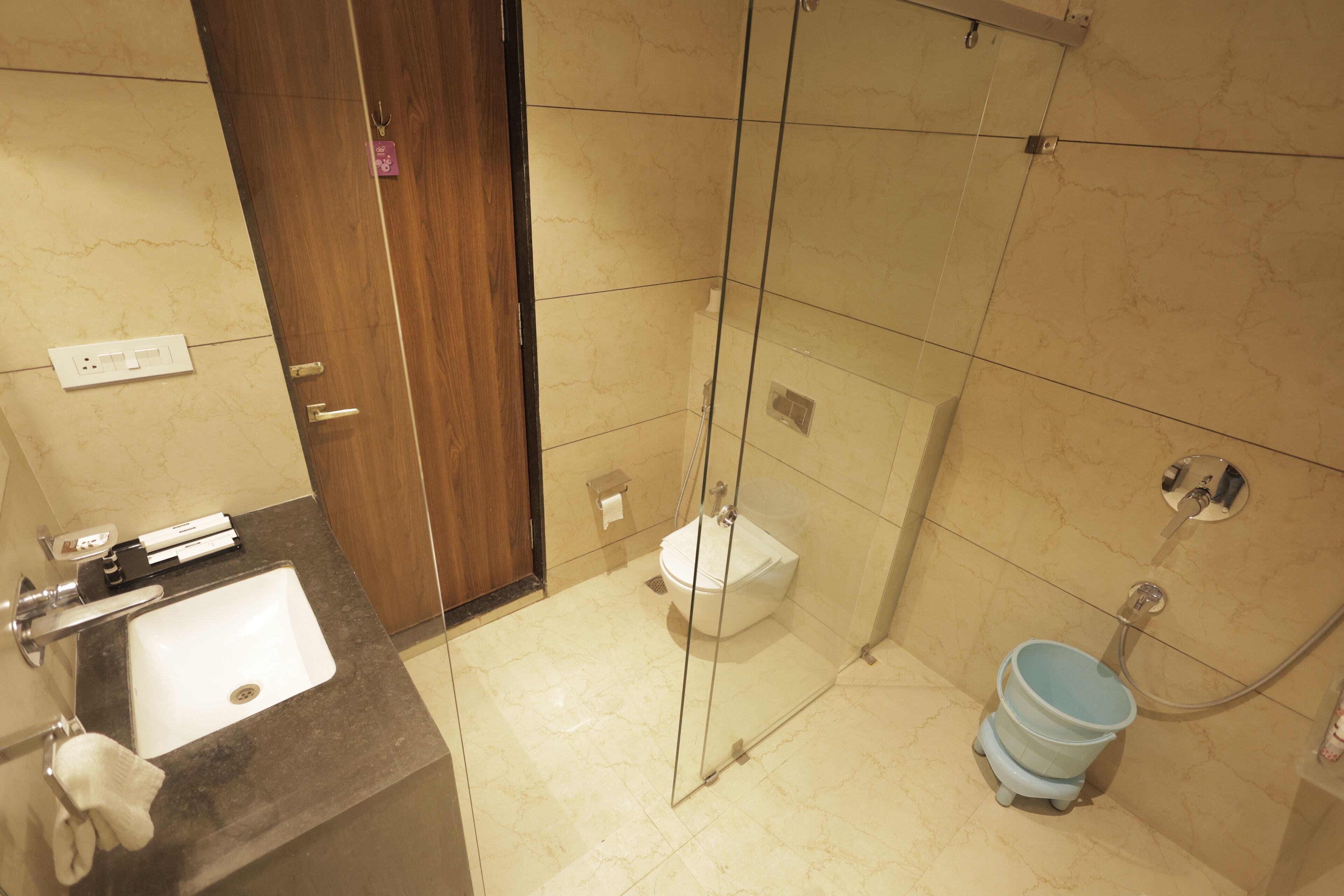 A modern bathroom with a glass-enclosed shower, a sink, and a toilet.