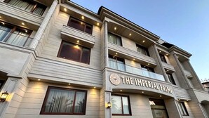 A multi-story hotel with a classic architectural design, featuring balconies and large windows. - The Imperial Prime (Bhilwara)