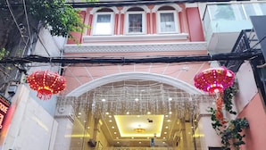 A hotel entrance with a reception desk, a staircase leading to the lobby, and decorative hanging lights. - Beautiful Hotel Bui Vien (Ho Chi Minh City)