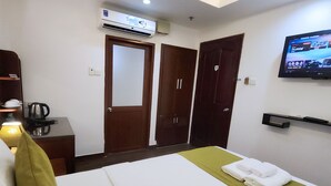 A hotel room with a bed, a TV mounted on the wall, an air conditioning unit, and a wardrobe. - Beautiful Hotel Bui Vien (Ho Chi Minh City)