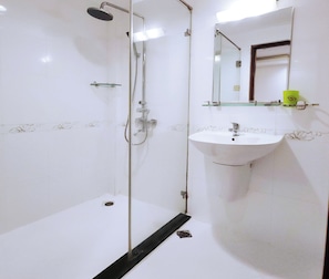 A bathroom with a glass-enclosed shower, a white sink, and a mirror above the sink. - Beautiful Hotel Bui Vien (Ho Chi Minh City)