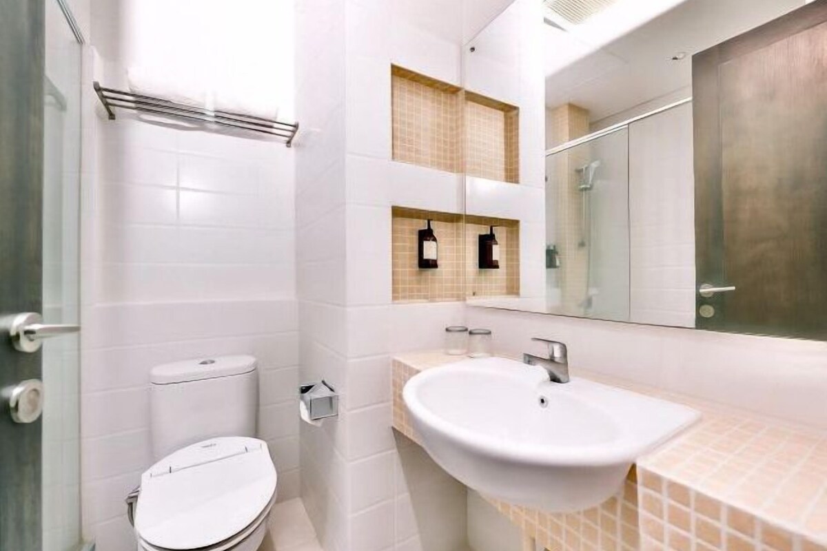 A modern bathroom with a toilet, sink, and mirror.