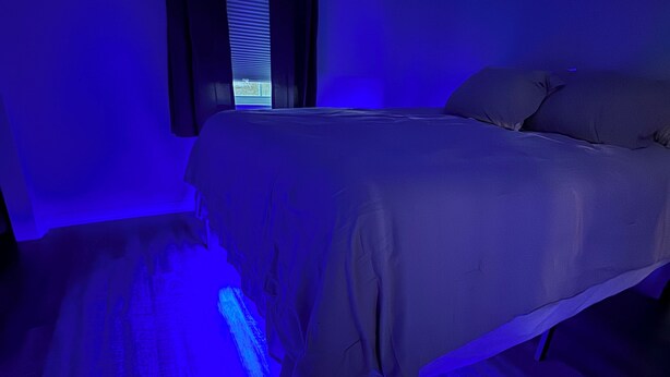 A bedroom with a bed, a window with curtains, and a ceiling fan.