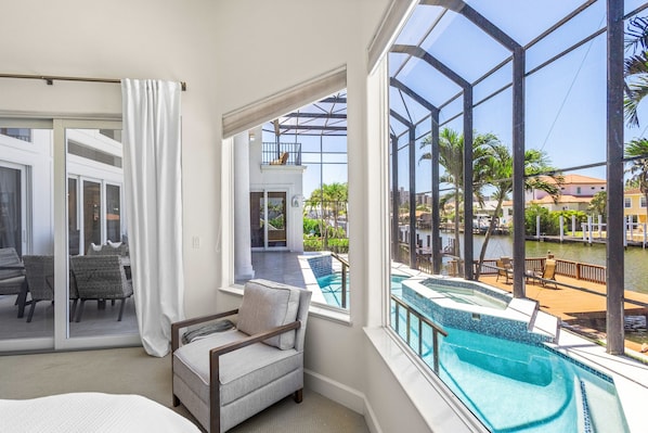 Relax in comfort with a view of the outdoor pool from the glass-enclosed balcony.