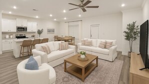 A modern living room with a sofa set, a coffee table, and a TV stand. - Sleeps 10 - The Salty Piper - Community pool (Santa Rosa Beach)