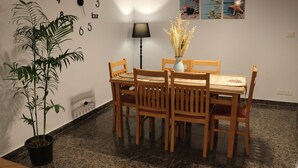 A dining area with a wooden table and chairs, a potted plant, a wall clock, and a lamp. -  NOUR1
Sea view (Alexandria)