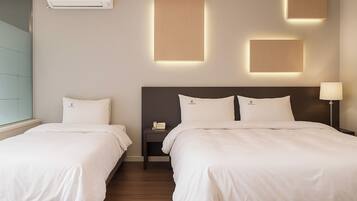 A hotel room with two beds, a wall-mounted air conditioner, and three illuminated wall panels.
