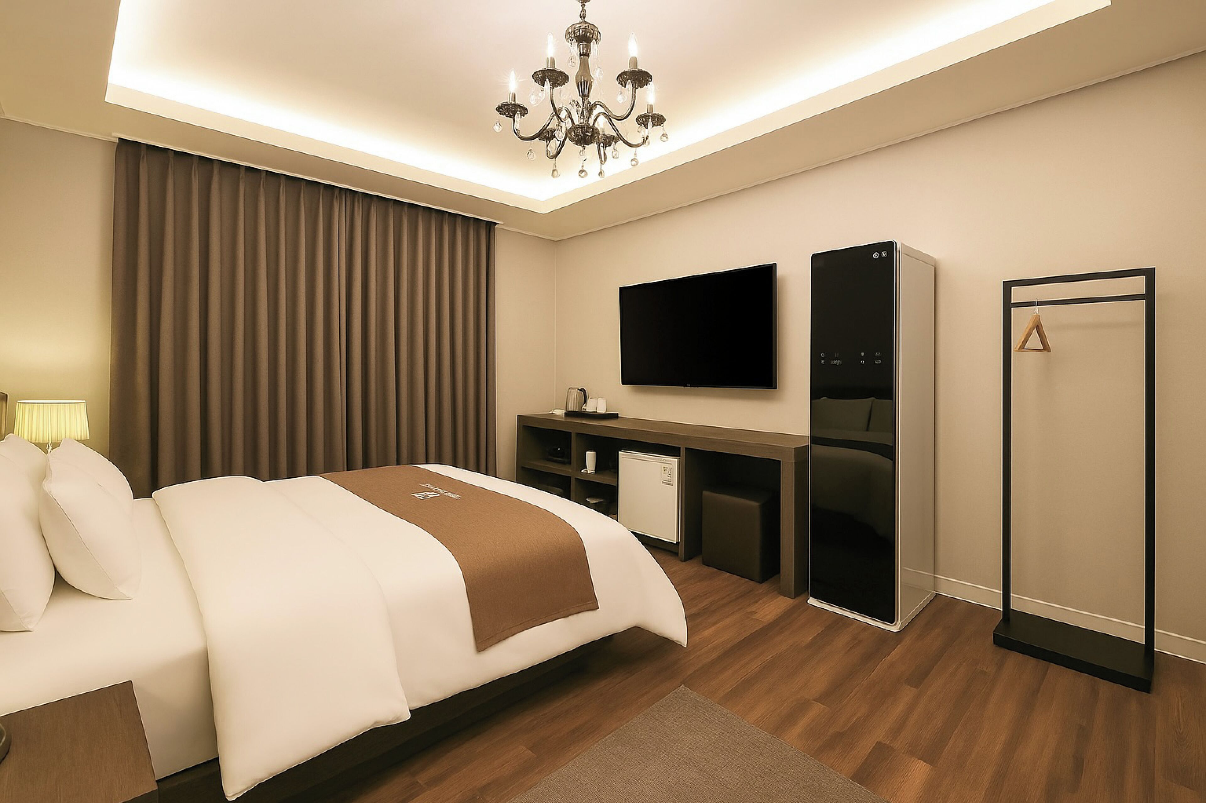 Quarto de hotel moderno com cama, secretária, televisão e guarda-roupa.