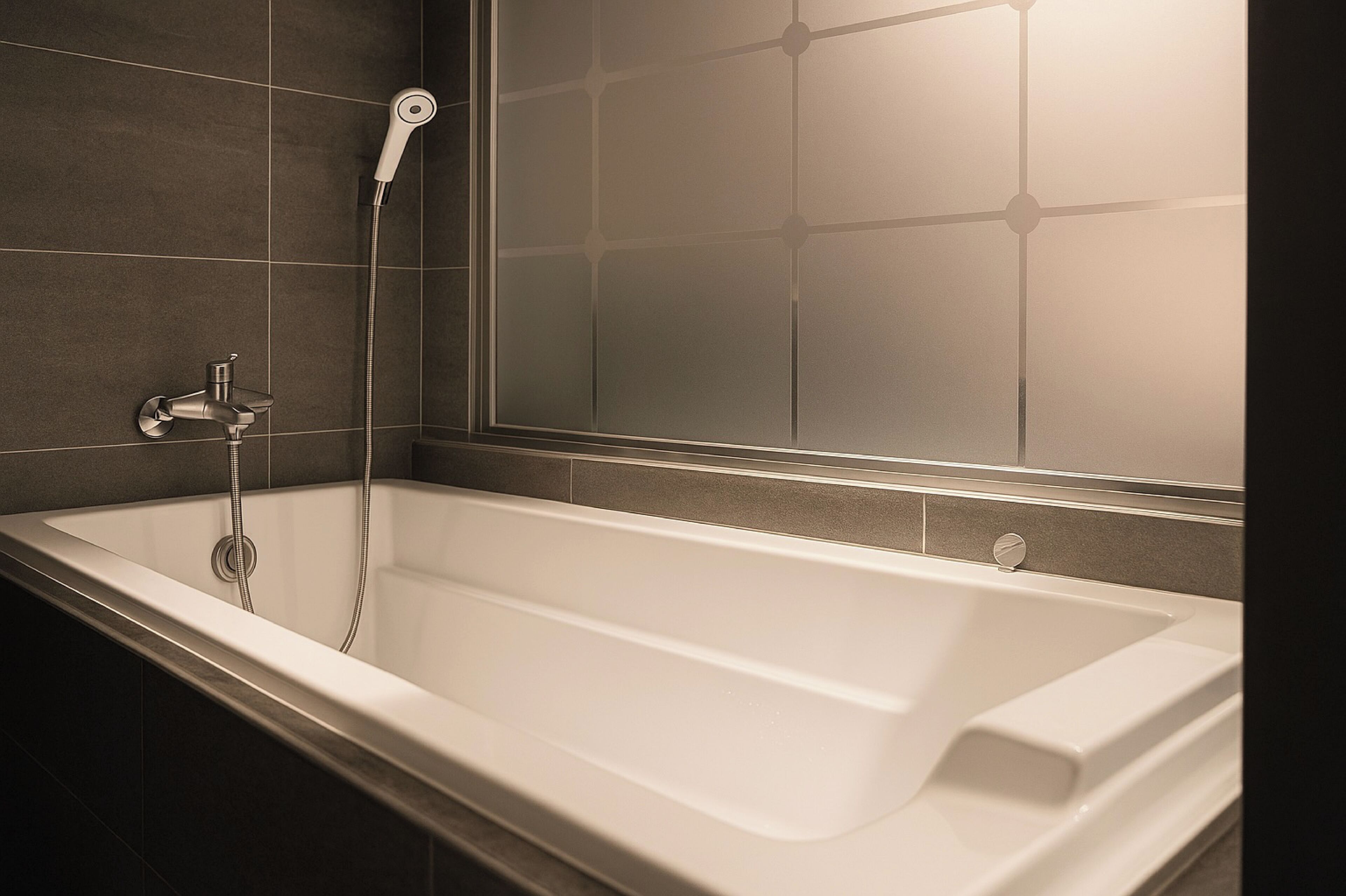 Une salle de bain moderne avec une baignoire sur pieds, une douchette et une cabine de douche en verre.