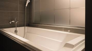Une salle de bain moderne avec une baignoire sur pieds, une douchette et une cabine de douche en verre.