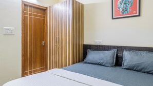 Un dormitorio con una cama, un armario y una obra de arte enmarcada en la pared.