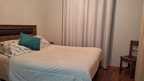 A bed with a headboard, a pillow, and a blanket.
