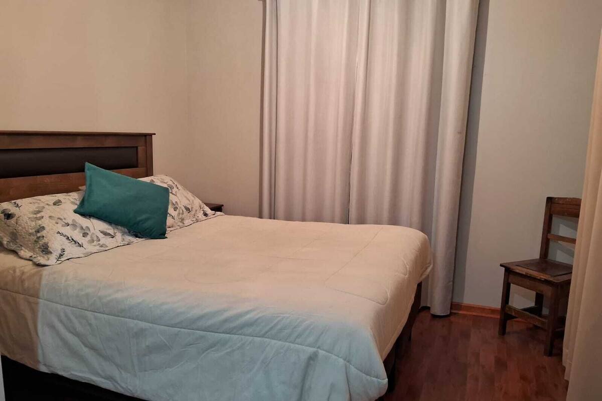 A bed with a headboard, a pillow, and a blanket.