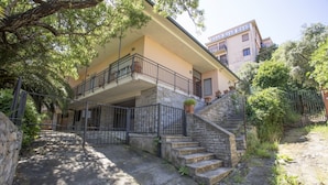 A two-story building with a stone staircase leading to a balcony.