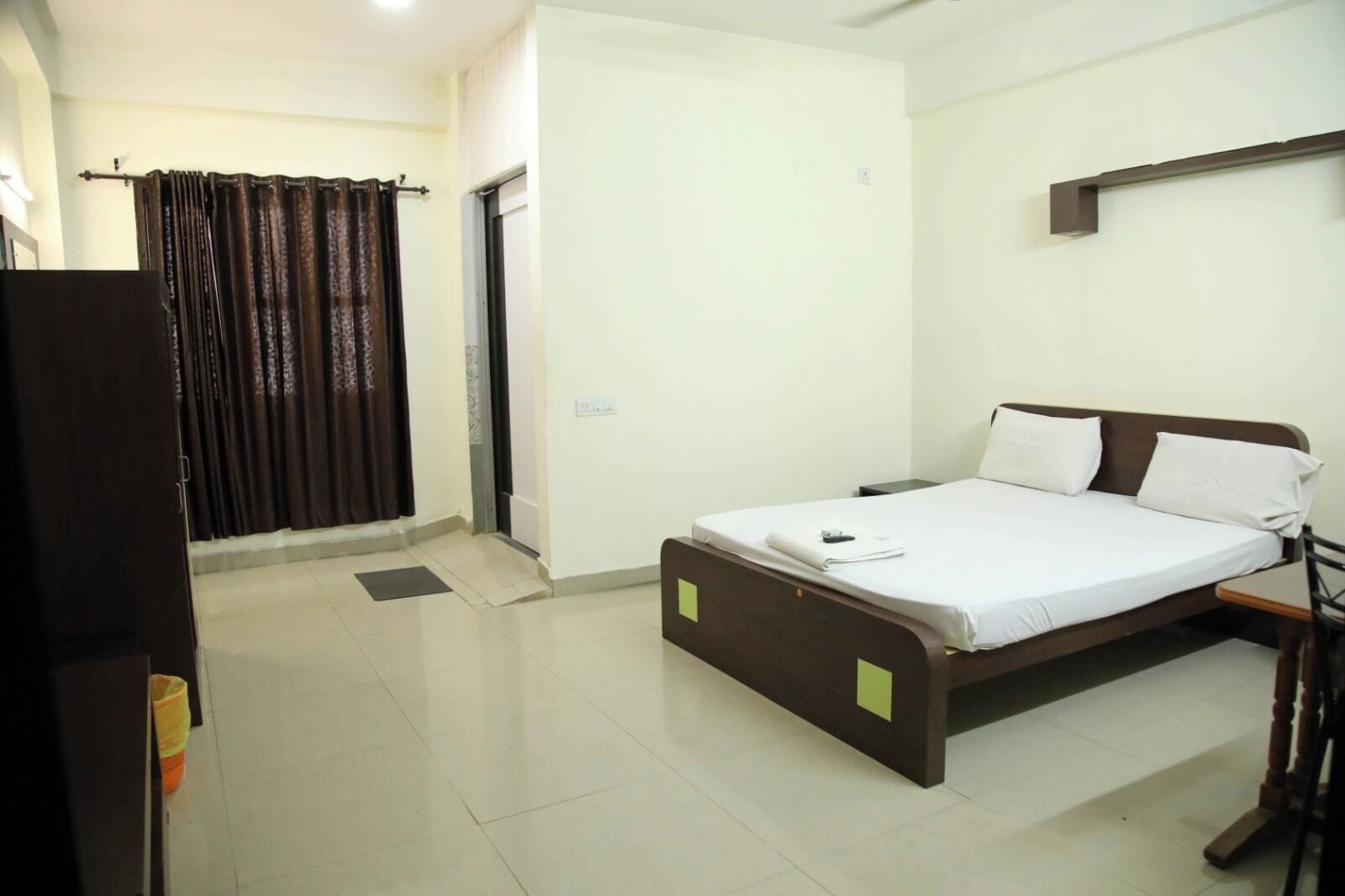 A bedroom with a bed, a wardrobe, and a curtain.