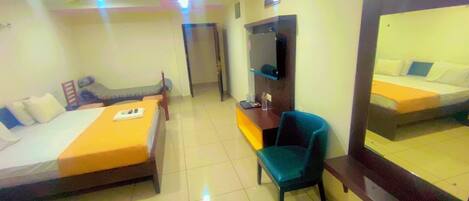 A hotel room with two beds, a desk, a chair, and a large mirror.