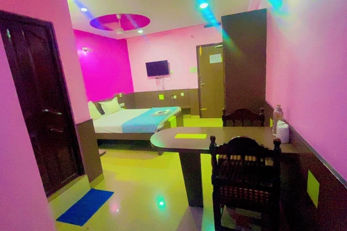 Una habitación de hotel con cama, escritorio, silla y televisor.