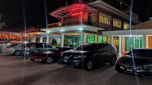 A hotel with a covered entrance and multiple cars parked in front. - Darul Salam Inn (Kerteh)