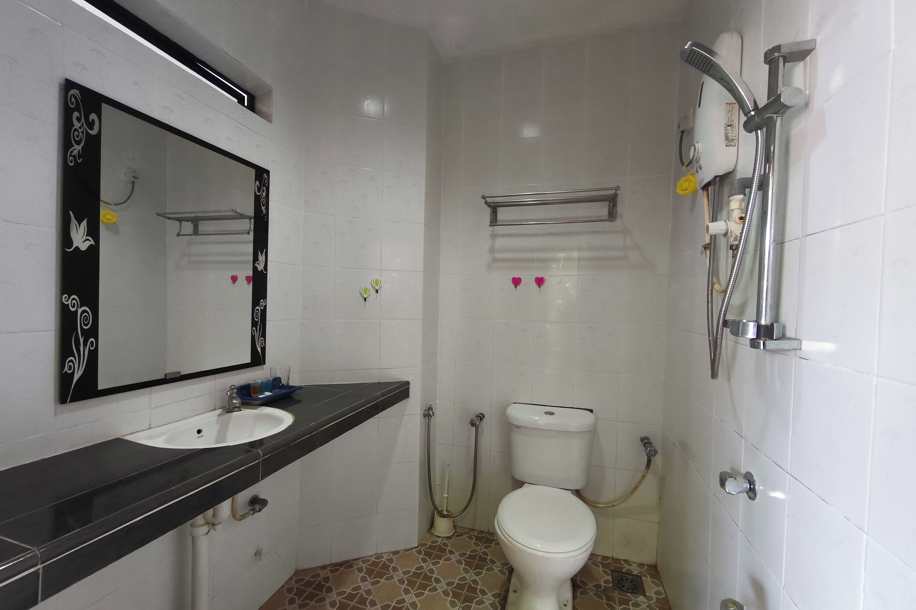 A bathroom with a white toilet, a sink, and a shower.
