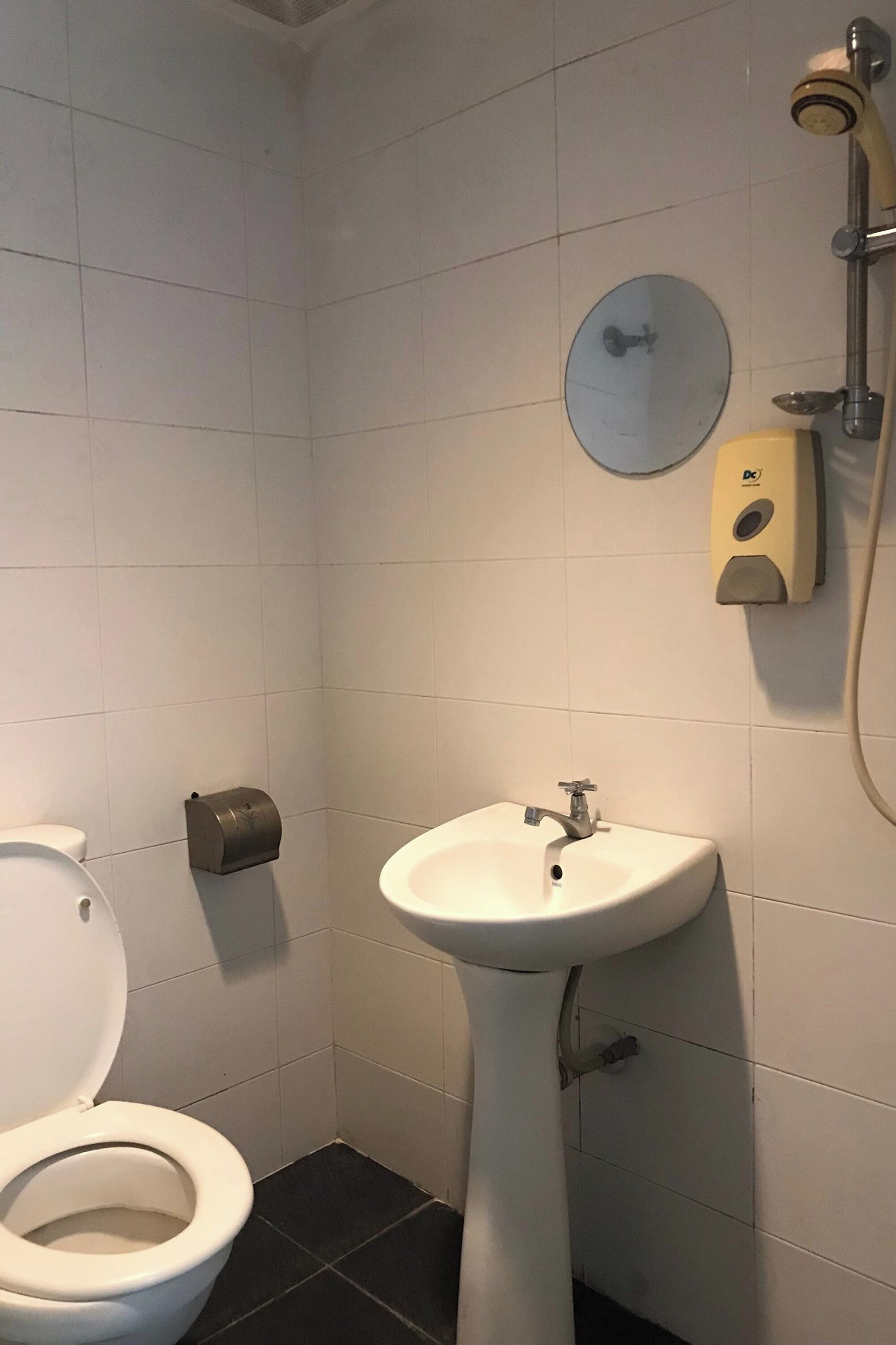 A small bathroom with a toilet, sink, and shower.