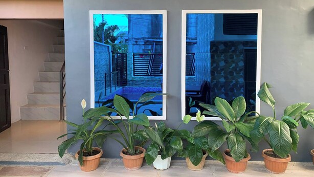 A staircase leading to a landing with potted plants and two framed photographs on the wall. - White-Beach Hideaway Resort Puerto Galera (Puerto Galera)
