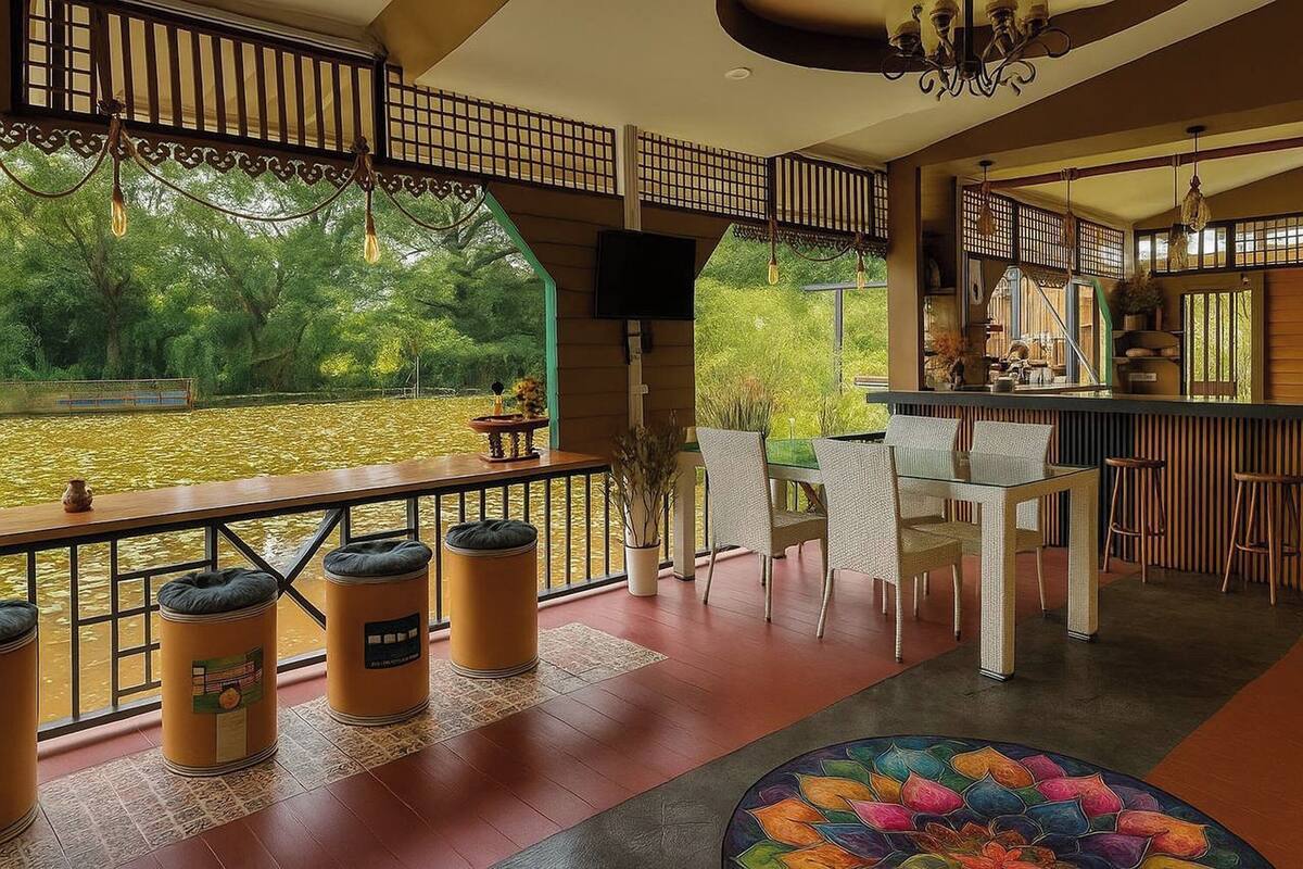 A spacious outdoor area with a dining table and chairs, a bar area, and a view of a water body.