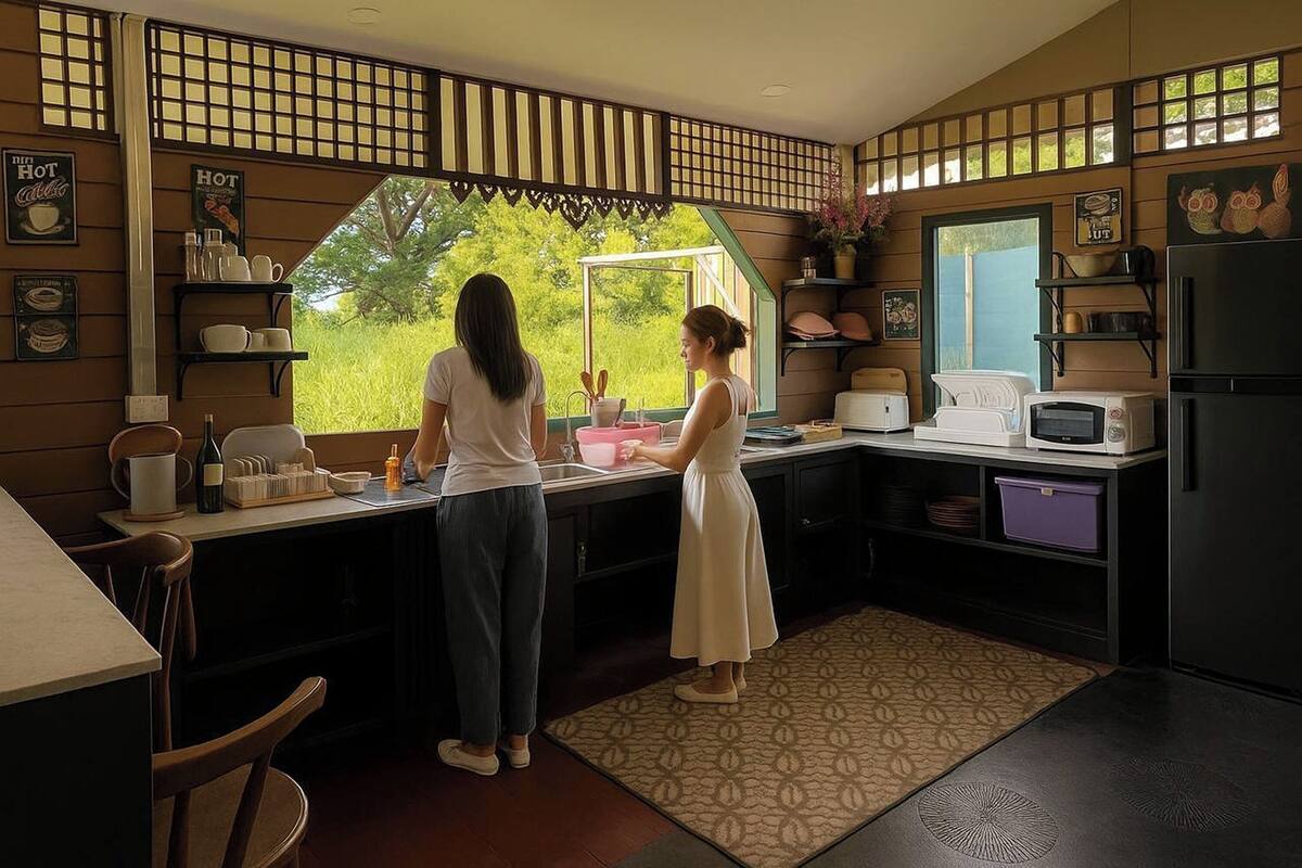 A kitchen with a large window, a microwave, a refrigerator, and a sink.