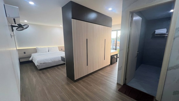 A bedroom with a bed, wardrobe, and a shower area. - Thao Trang Luxury Hotel Dong Hoi (Dong Hoi)
