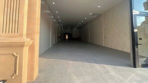 A hallway with a marble floor and walls, leading to a door with a glass panel. - Thao Trang Luxury Hotel Dong Hoi (Dong Hoi)